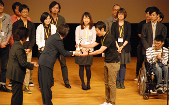 Director Kojima presents trophies to the winning teams